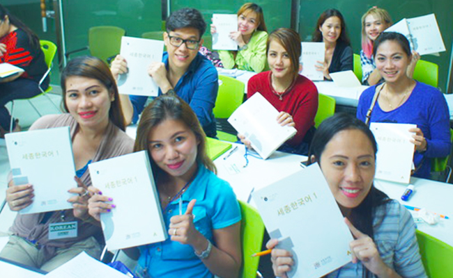 KSI learners of Cebu, Philippines take the first class of the first semester, holding Sejong Korean and smiling.